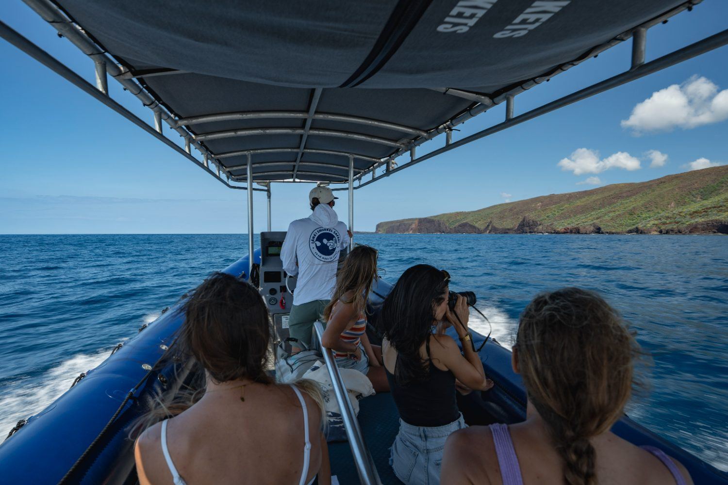 Guests watching the Lānaʻi coastline come up from under the raft canopy