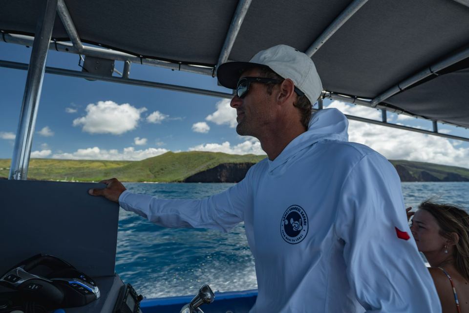 A crew member under the canopy watching the Lānaʻi shore ahead